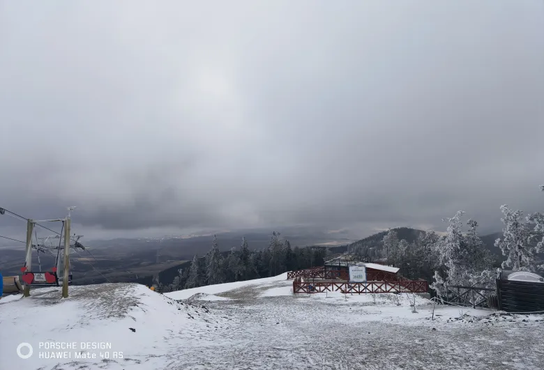 照片：山顶的观景平台与缆车索道终点，地面覆着薄雪，远处山峦起伏。